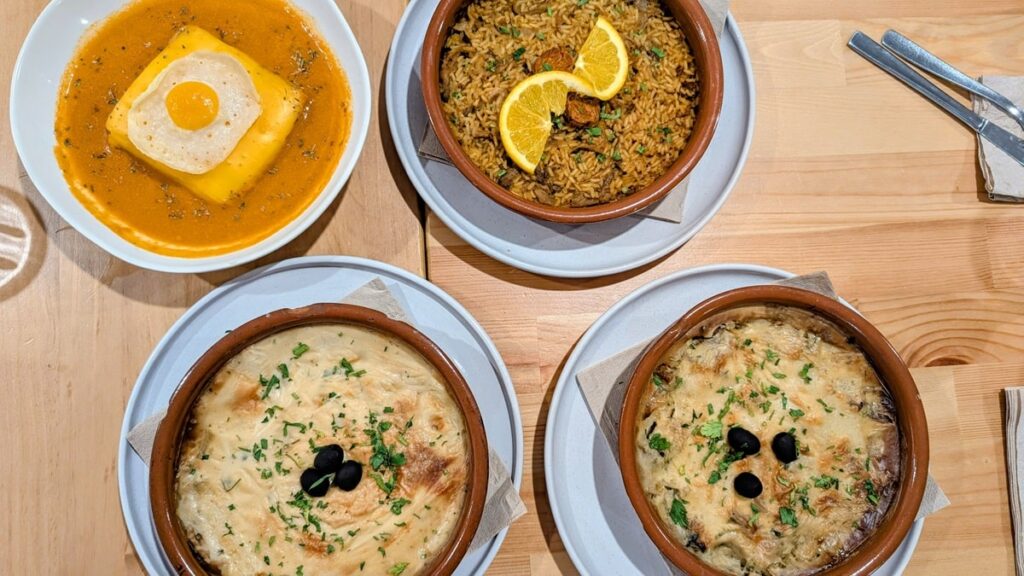 four traditional portugese dishes all vegan on a wood table at A Minha Avó in lisbon