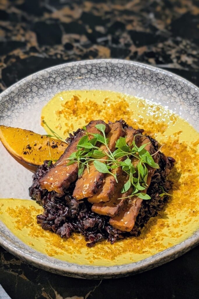 vegan tempeh curry with a bright yellow sauce at ao vegan project in lisbon