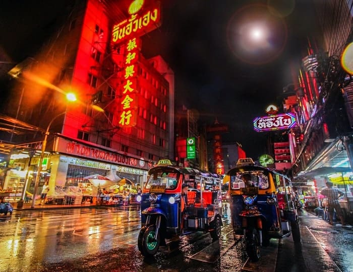 busy bangkok street at night with the glow of street lights vegan tour 2023