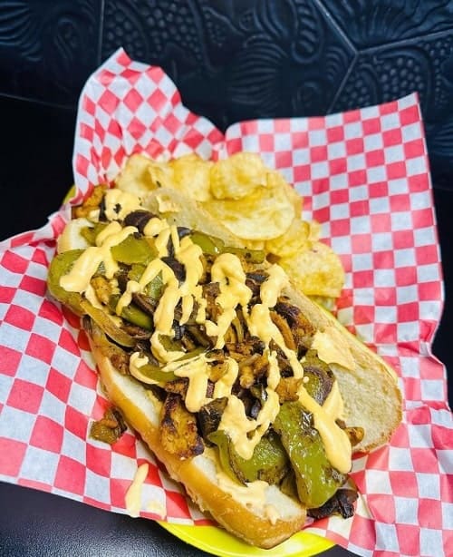 a red and white checker basket filled with a vegan philly cheese steak sandwich at detroit street filling station in ann arbor