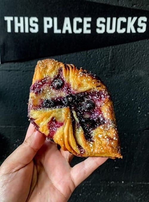 vegan berry pastry held in front of a dark black wall at the vegan bakery lavender and vanilla in nashville