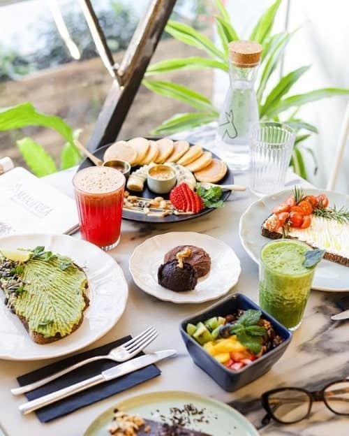 vegan breakfast spread including avocado toast, fruit, juices at manjerica in lisbon