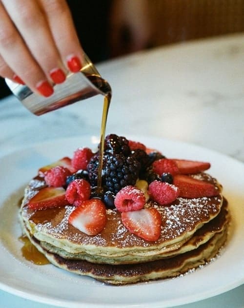 a plate of vegan pancakes topped with berries and syrup for vegan brunch at margots in LA