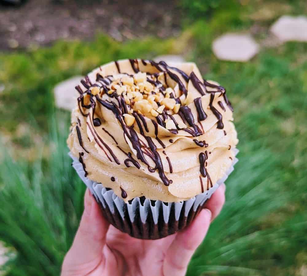 a single vegan chocolate cupcake topped with peanut butter buttercream and a chocolate drizzle from the sunflower bakeshop in nashville