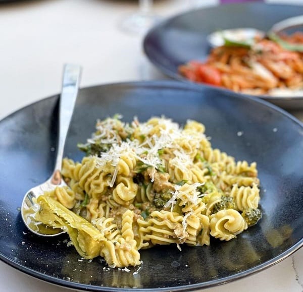 vegan italian cream pasta in a black bowl in front of a tomato based pasta at BAIA in San Francisco