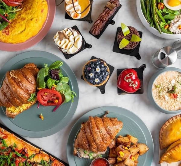 vegan pastries and croissant breakfast sandwiches spread across a table 