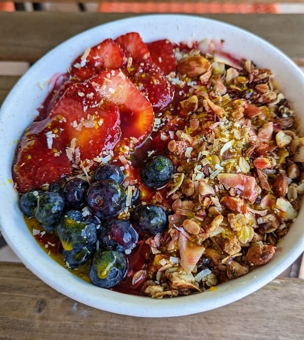 vegan acai bowl topped with strawberries, blueberries, and granola at manna life in miami