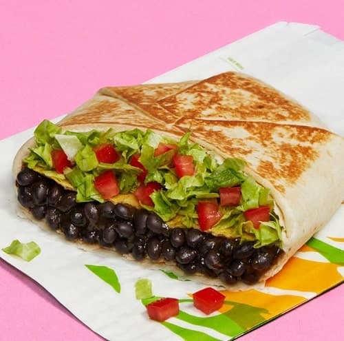 vegan black bean crunch wrap from taco bell on a pink background
