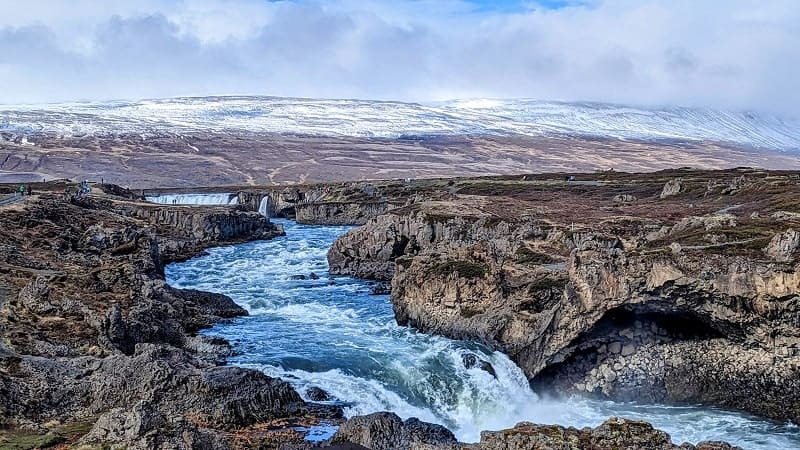 Godafoss Waterfall with snowcapped mountains in the background
