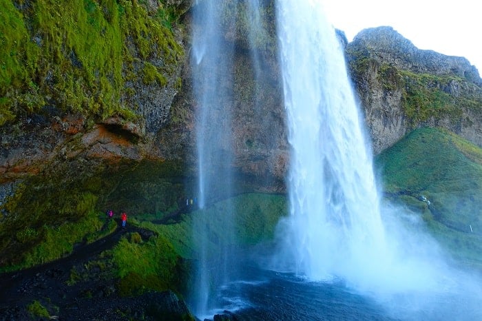 the beautiful Seljalandsfoss waterfall taken from along a hiking trail that leads behind the waterfall in iceland