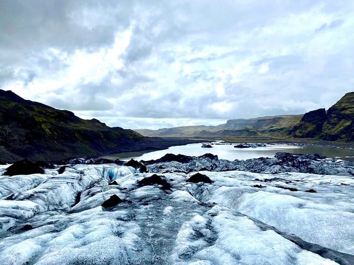 the white, icy blue and black streaked Solheimajokull glacier looking down into the glacier lagoon in iceland on a day trip from Reykjavik 