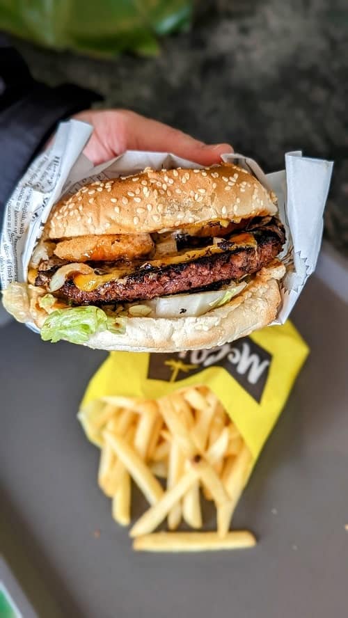 junkyard vegan restaurant loaded burger held above an order of french fries in Reykjavik