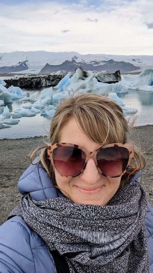 rebecca gade sawicki at the Jökulsárlón Glacier Lagoon with icebergs floating in the background on a g adventures tour