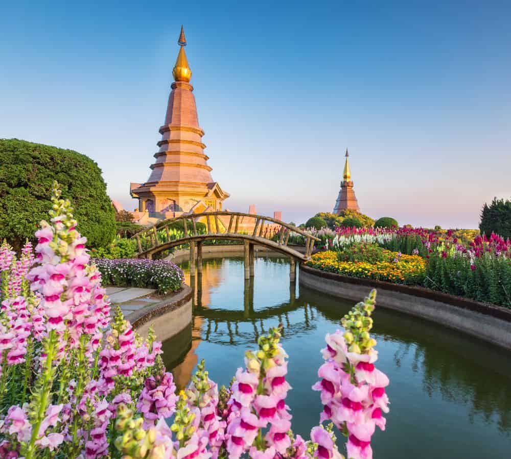 traditional temple along a river in thailand at sunset