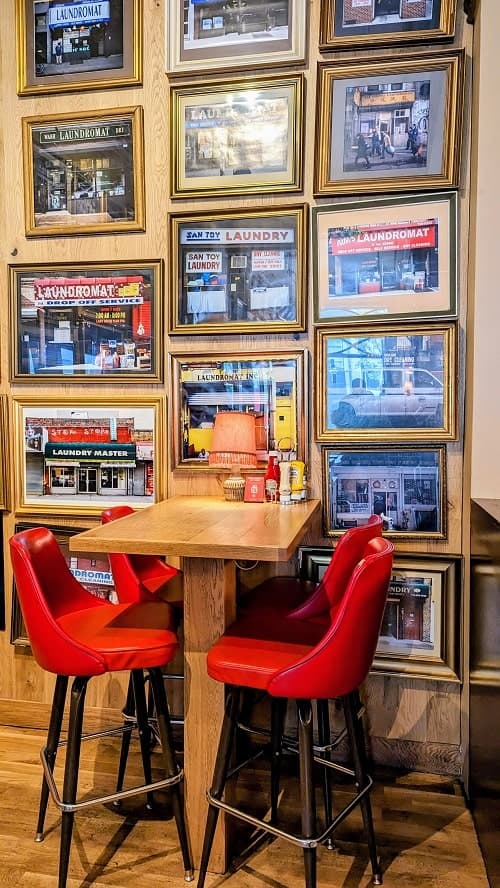 the inside seating area with a high table and red chairs at the laundromat cafe in reykjavik