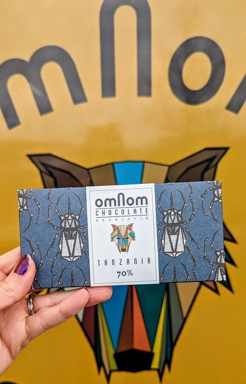 a bar of vegan chocolate from Nicaragua held in front of the omnom logi in Reykjavik