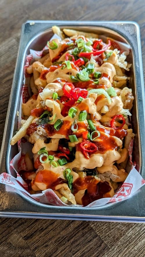 an order of vegan fiflthy fries covered in kimchi, sauce, and peppers at kore in Reykjavik