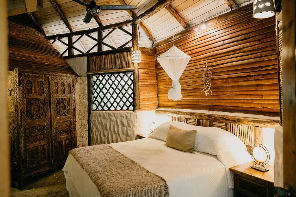 rustic guestroom with wood finishes and natural bedding at Natura Cabana Boutique Hotel & Spa in the domincan republic