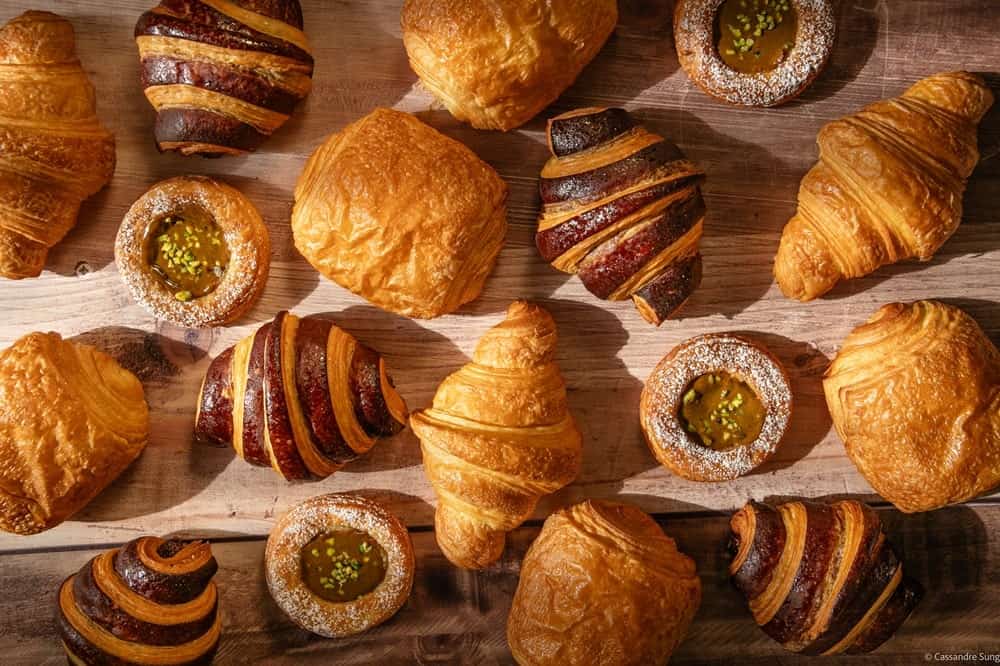 beautiful vegan croissants and pastries laid out over a table in paris