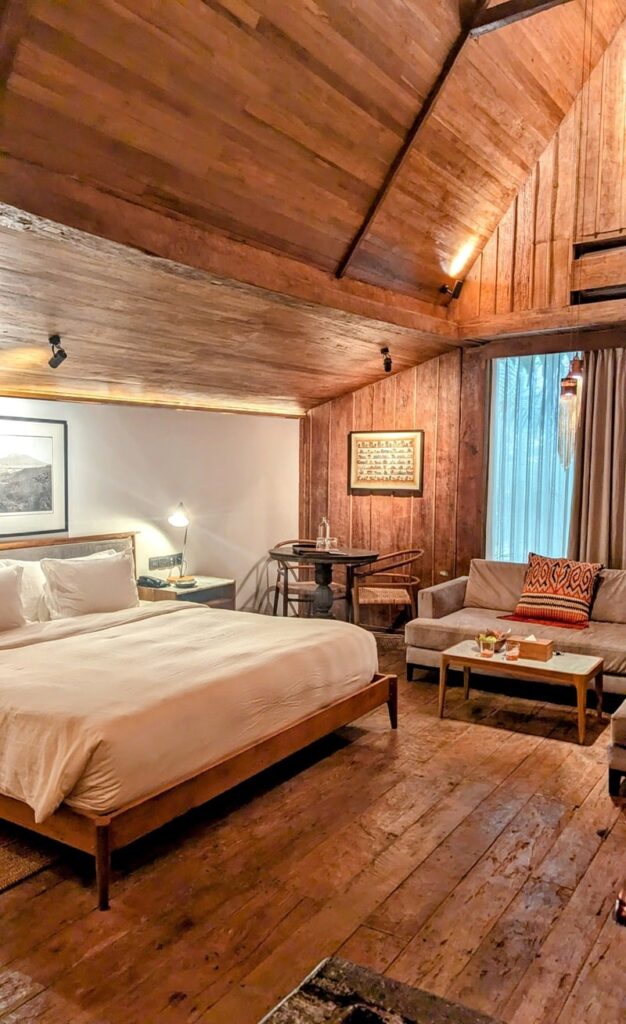 a rustic suite with light wood accents and a white linen covered bed at asa maia in bali