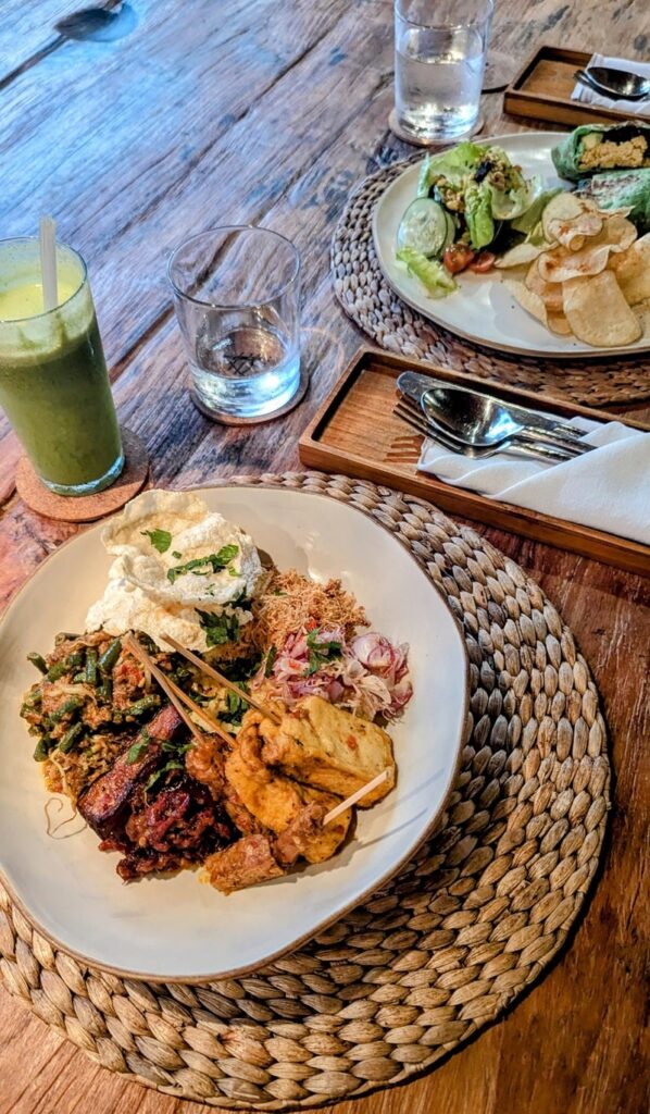 vegan tempeh and rice in a white bowl next to a green smoothie at asa maia in bali