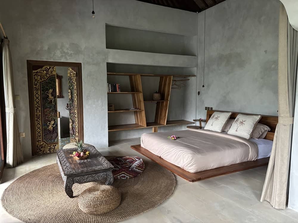 modern guestroom with earthy tones and a large double bed at the vegan hotel harmony hill in ubud