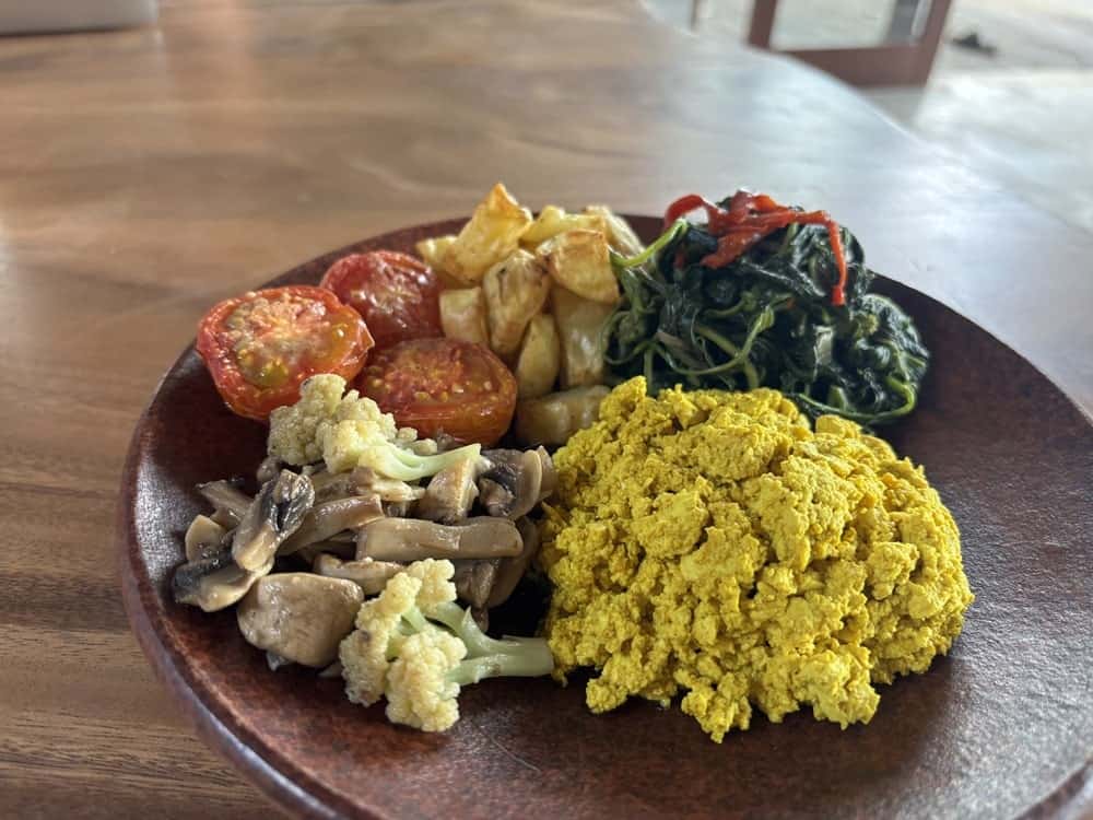 vegan breakfast platter with scrambled tofu, mushrooms, tomato and greens at harmony hill in ubud, bali