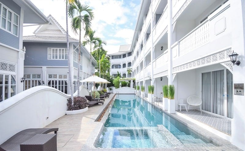 white colonial building surrounding a long rectangular pool at the vegan friendly resort away chiang mai 