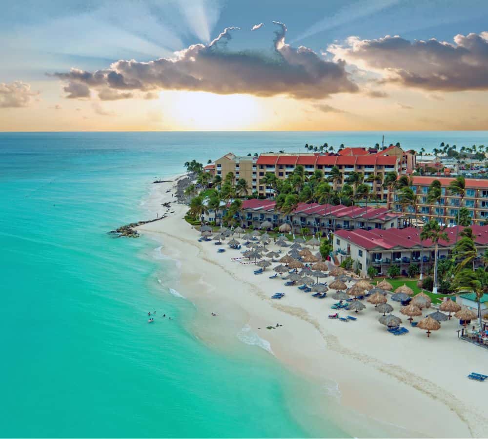 overhead view of a large resort on the beach surrounded by turquoise water in aruba