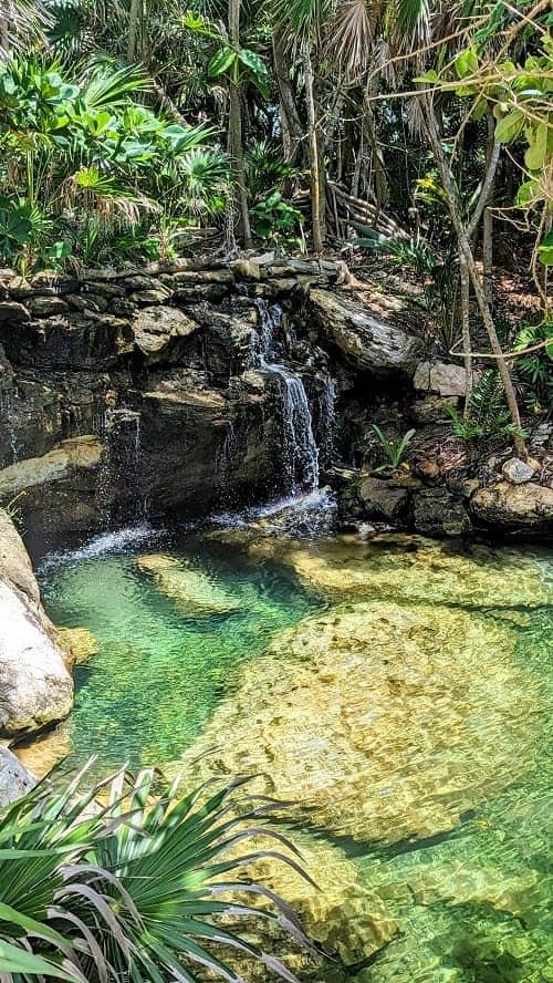 natural cenote and waterfall at the palmaia resort in playa del carmen