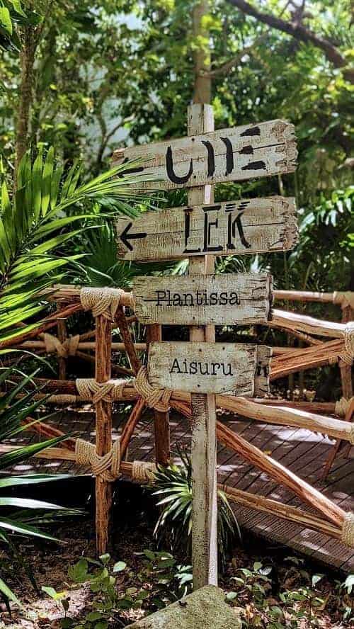 wooden sign directing visitors to different dining options and areas at the palmaia resort in playa del carmen