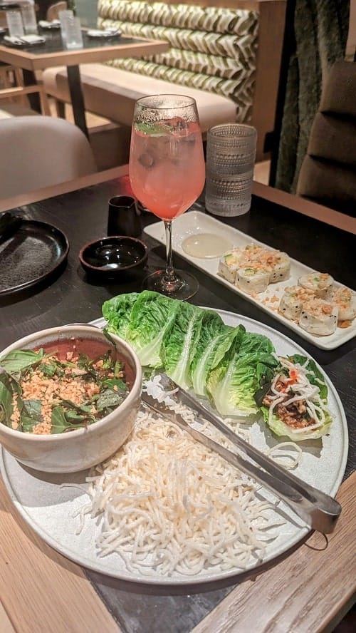 vegan thai lettuce rolls next to a pink cocktail and sushi at PLANTA in west palm beach