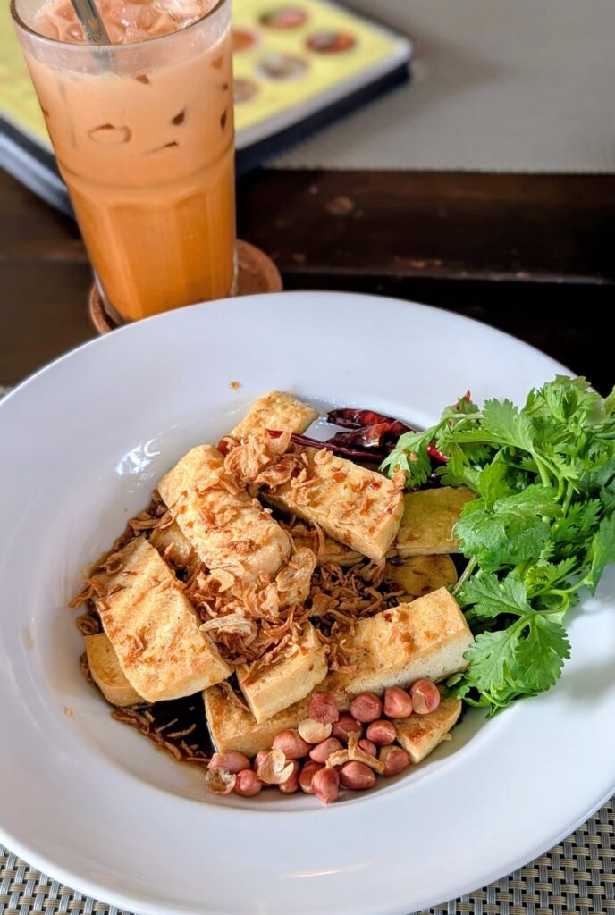 vegan tamarind tofu with a thai tea at the vegan restaurant reform kafe which is connected to the vegan hotel green tiger house in chiang mai thailand