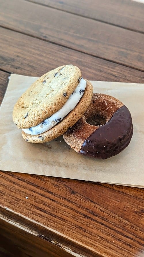 a vegan cookie sandwich next to a churro donut dipped in chocolate at parlour vegan bakery in boca raton