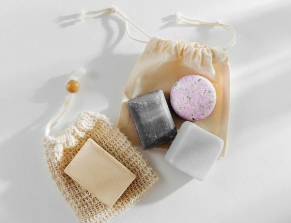 four vegan shampoo and conditioner bars sitting on a mesh bag