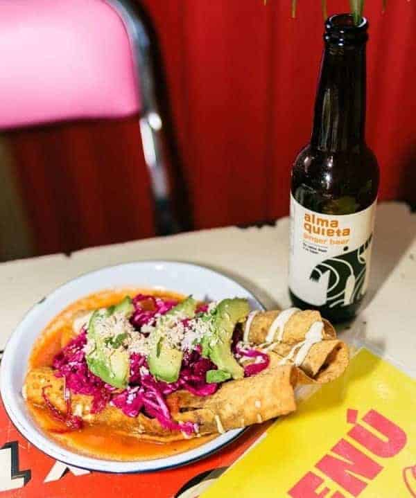 vegan corn taquitos topped with avocado next to a beer at the vegan restaurant gracias madre in mexico city