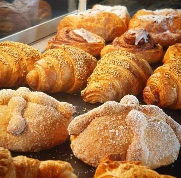 rows of golden vegan croissants and pastries at the vegan bakery migas vegana in mexico city