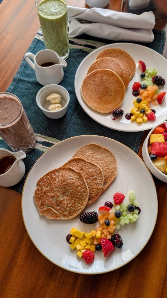 two orders of vegan and gluten free pancakes with smoothies and fresh fruit at the palmaia