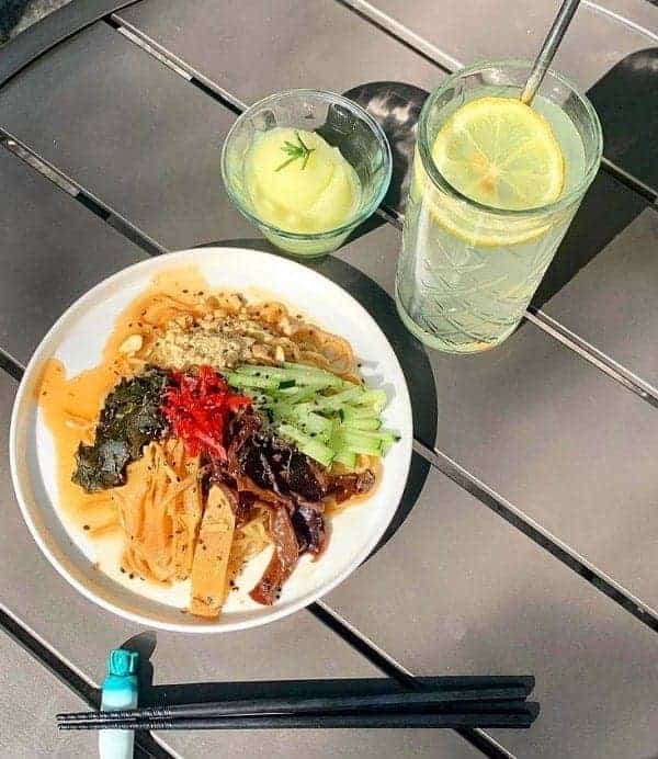 colorful japanese dish on an outdoor table next to two drinks at the vegan restaurant vegan ramen mei in mexico city