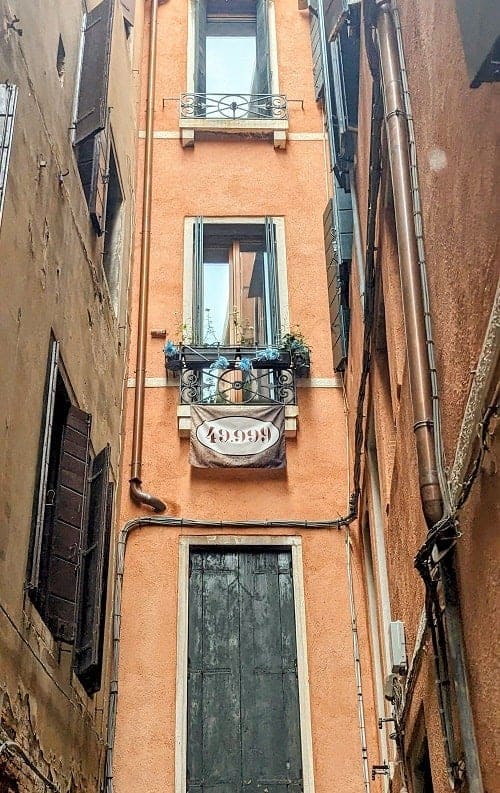 a banner hanging from a balcony in venice that says 49999