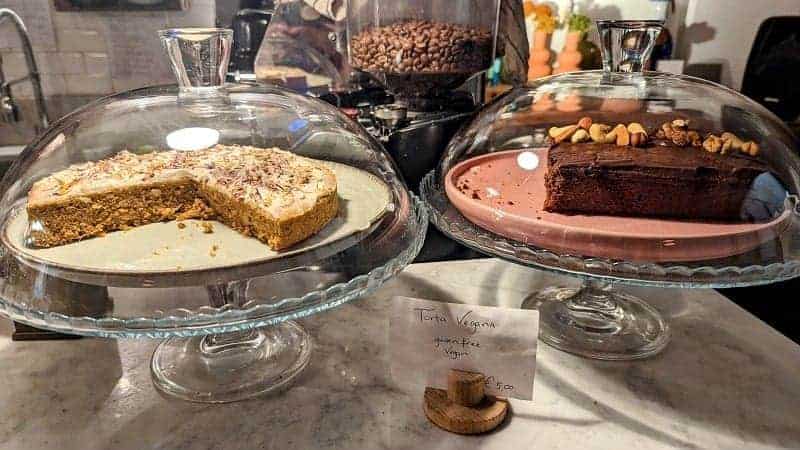 two vegan cakes sitting on glass cake stands at Carduccio - Il Salotto Bio  in florence
