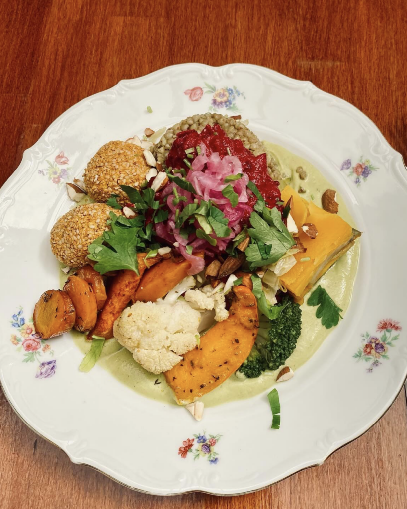Colorful vegan and gluten-free dish at Les 4 Jeudis Brussels with roasted vegetables, grains, falafel, pickled onions, and creamy sauce.