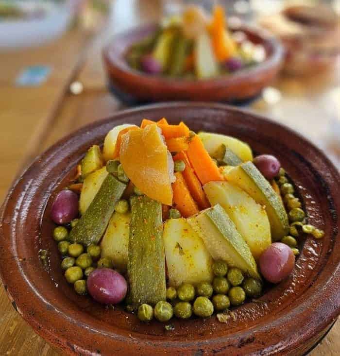 vegan vegetable tajine on a wood table at ayaso bio restaurant in marrakesh 