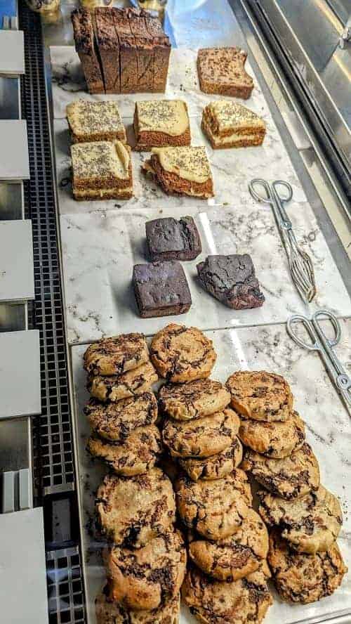vegan and gluten free cookies and cakes in a dessert case at base v juicery in florence