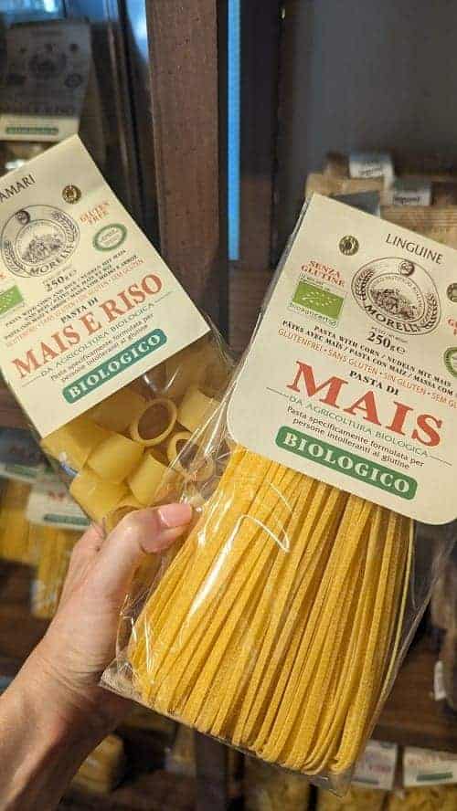two packages of gluten free pasta held in one hand