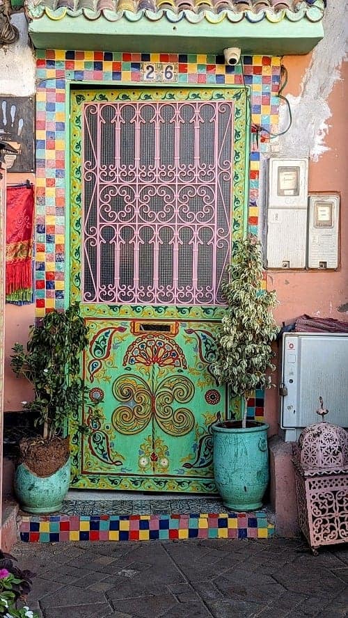 a green door painted with colorful designs in the marrakech medina