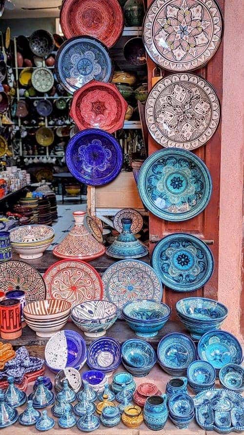 a display of colorful bowls and tajines in a small shop in the marrakech medina