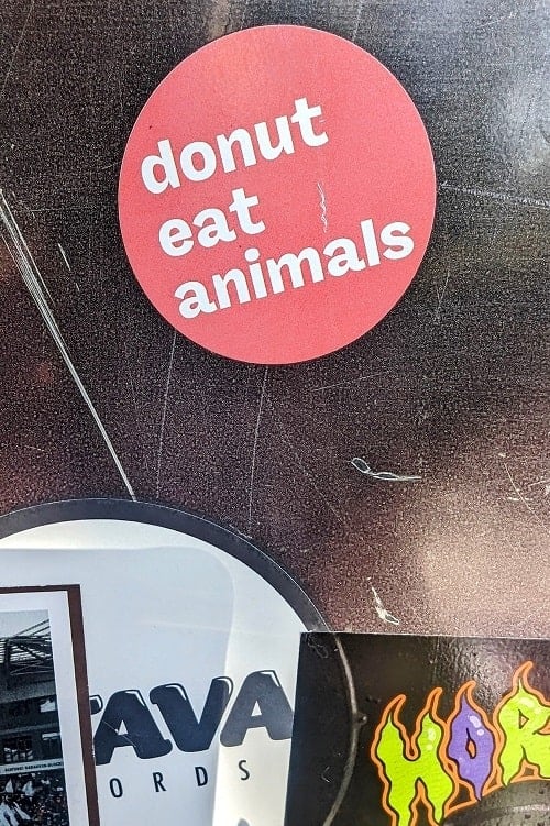 pink sticker on a black background that says donut eat animals in hamburg