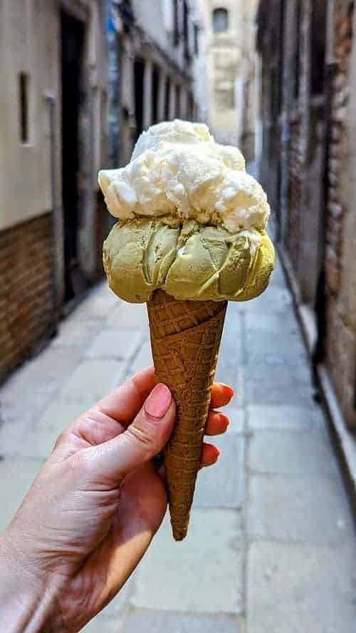 a scoop of pistachio and banana vegan ice cream on a waffle cone in venice italy