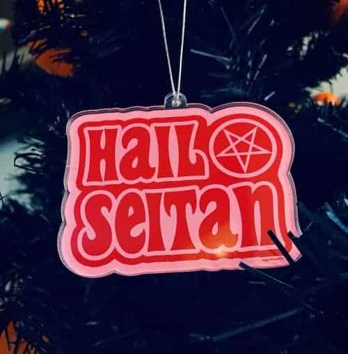 a pink and red christmas ornament that says hail seitan